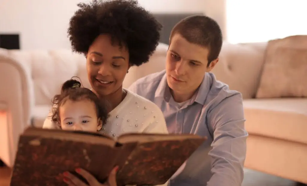 Three generations share a story together on the living room floor, highlighting family bonds and a love for learning.